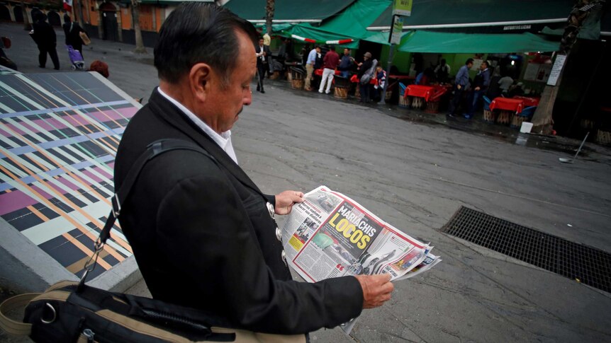 Mariachi musician reads newspaper
