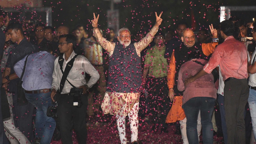 Indian Prime Minister Narendra Modi and BJP President Amit Shah are showered with rose petals as they greet supporters.