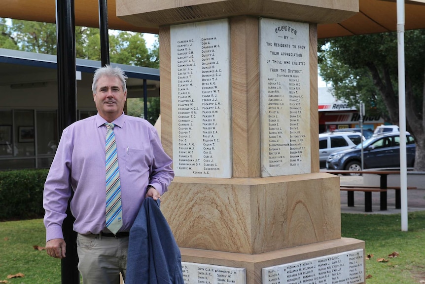 Man stands in front of a monument.