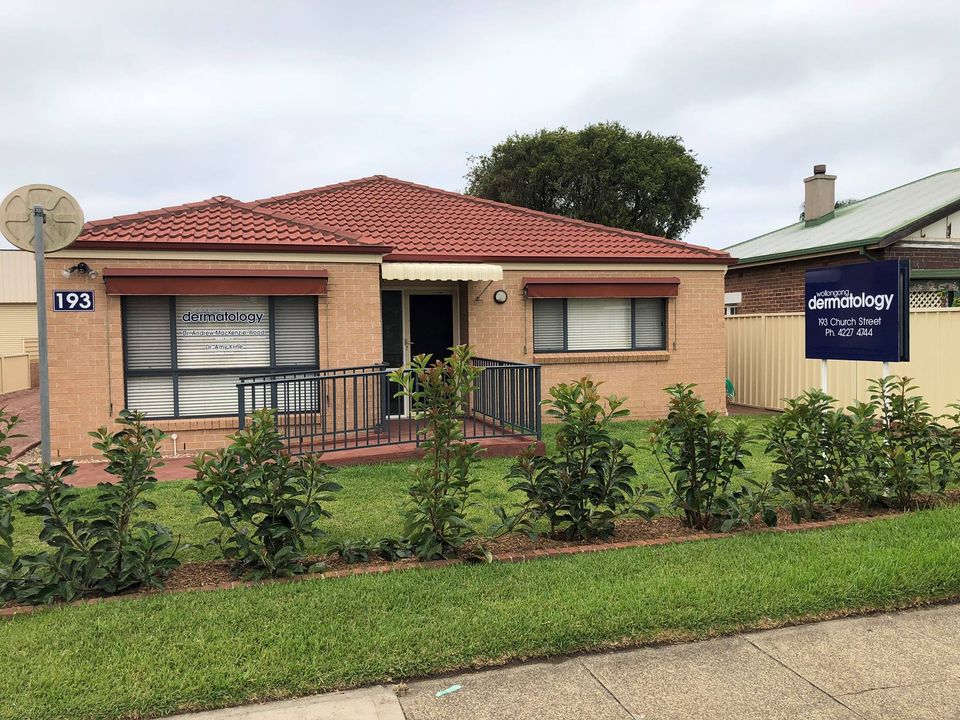 A residential-looking, brick rendered building that operates as a dermatology practice in a regional city.