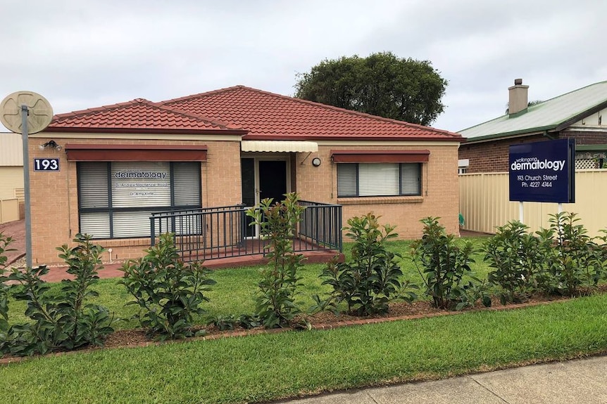 A residential-looking, brick rendered building that operates as a dermatology practice in a regional city.