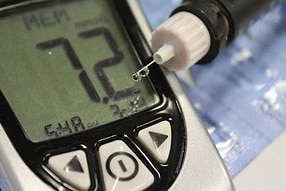 Insulin testing equipment with a needle to the right and a small electronic device for testing levels left