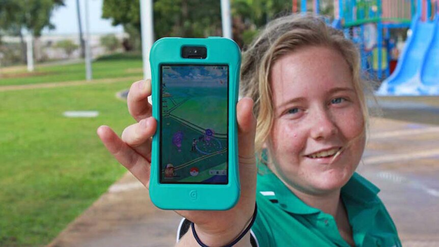 Claire Kelly holds out her phone to show the Pokemon Go app