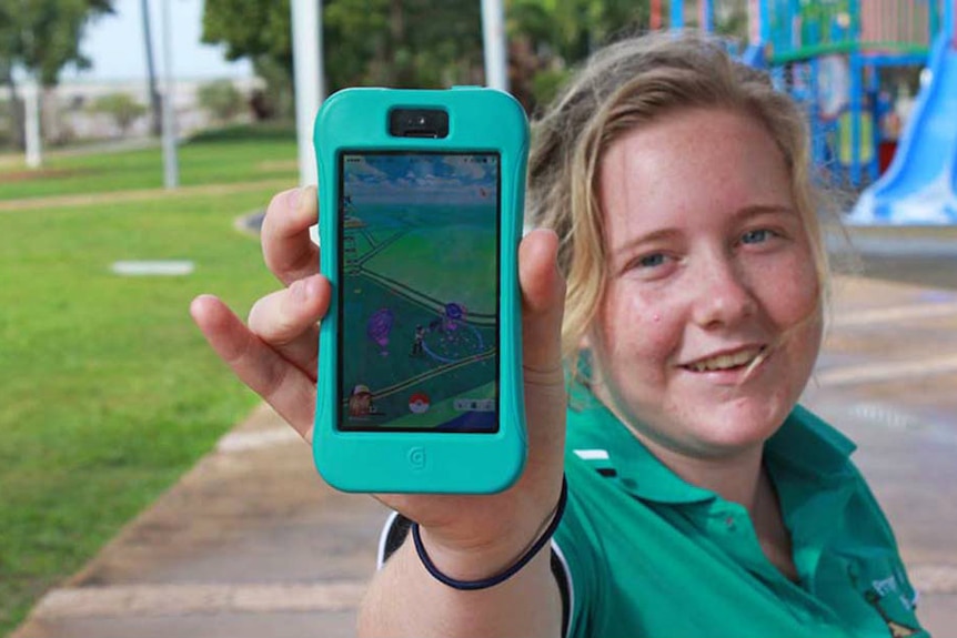 Claire Kelly holds out her phone to show the Pokemon Go app