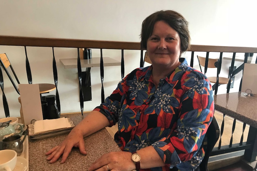 A woman sits in a cafe.