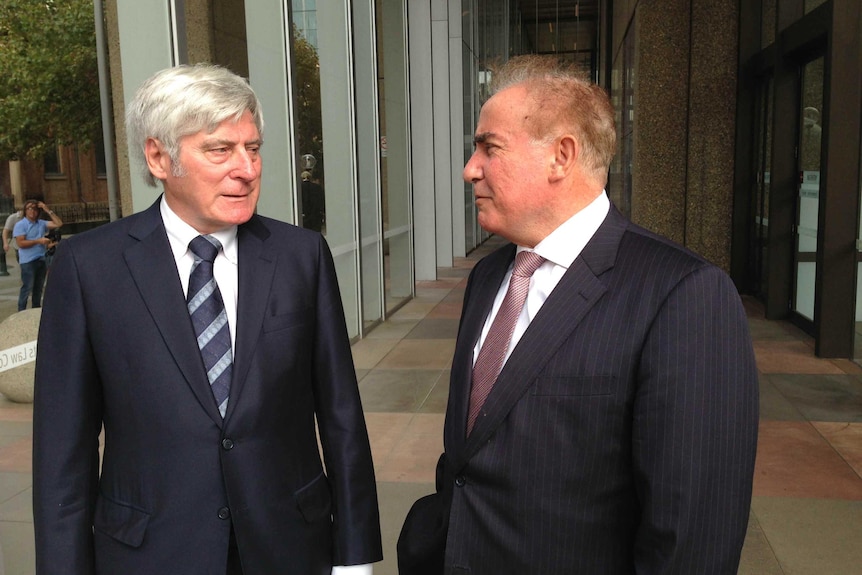 Two men standing in a court corridor.