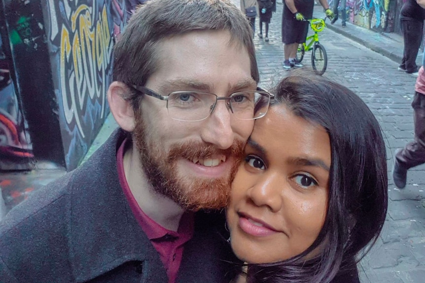 Andrew and Silvia take a selfie in a graffitied laneway.