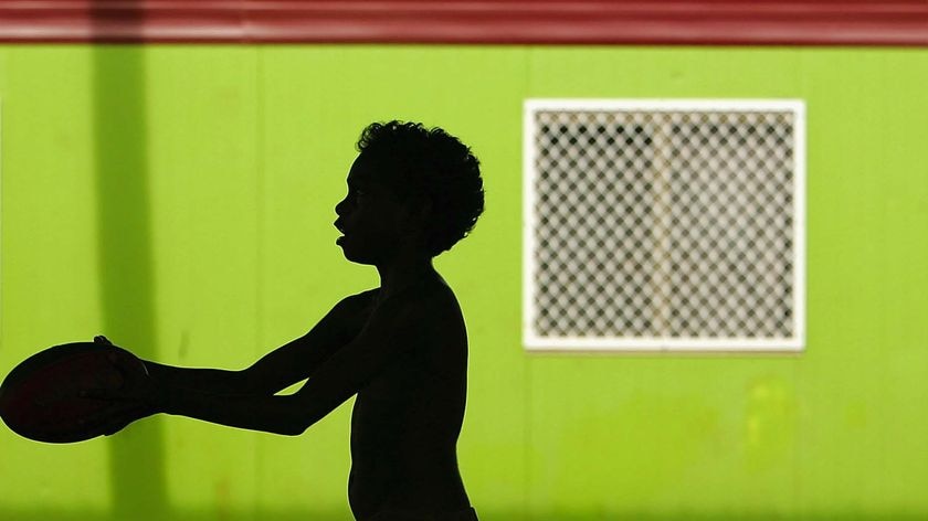 An aboriginal child plays with a football