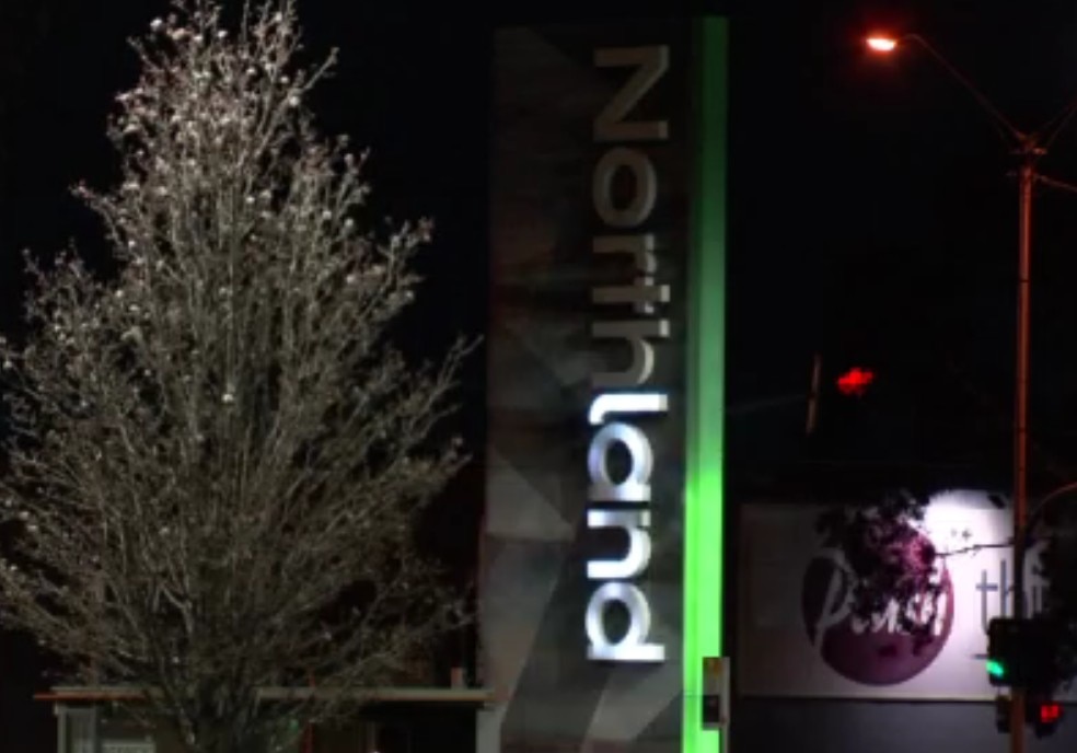 An external sign for Northland Shopping Centre, partially illuminated.