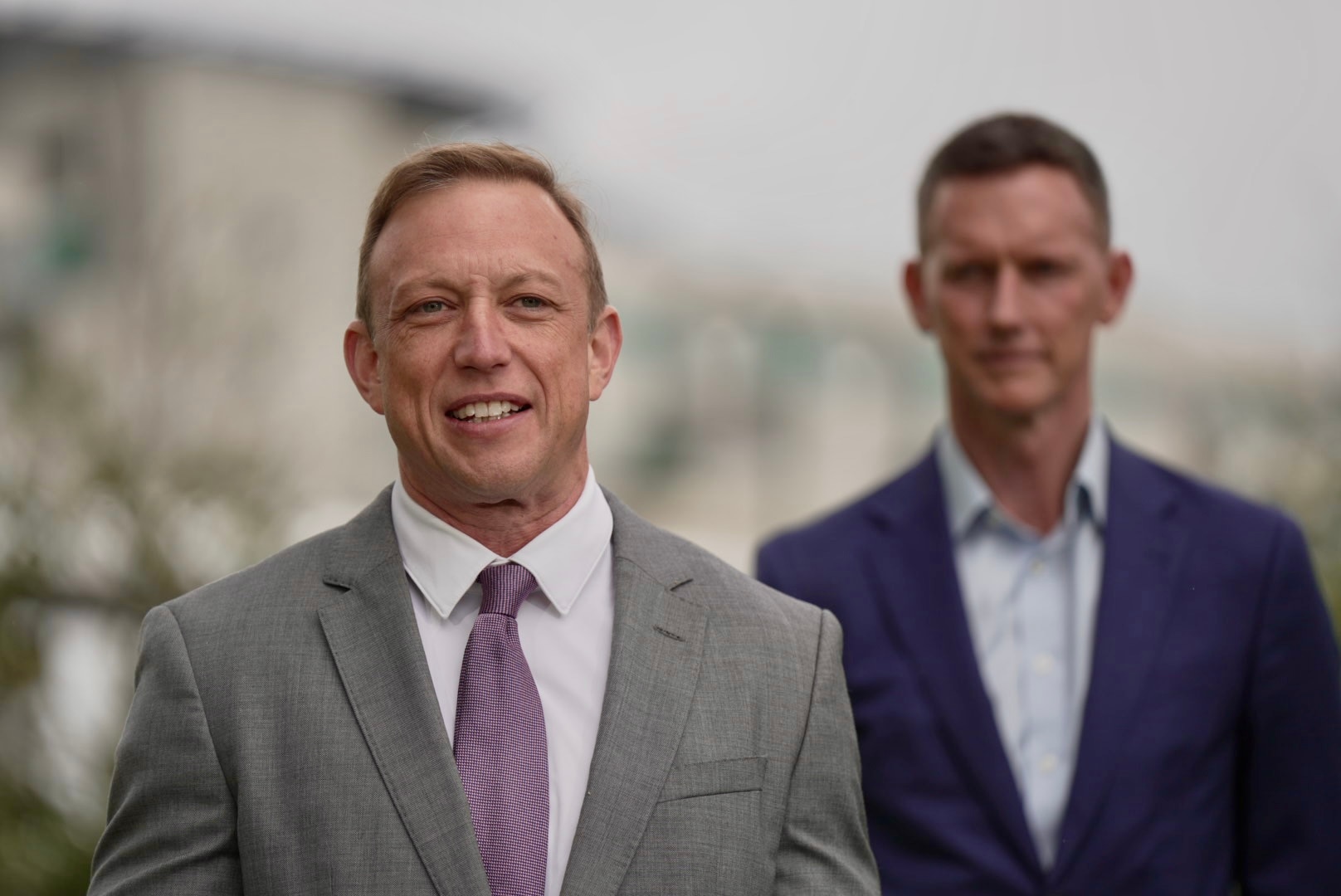 A photo showing Steven Miles standing with another man behind him.
