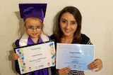 Mother and daughter smile holding HIPPY graduation certificates.