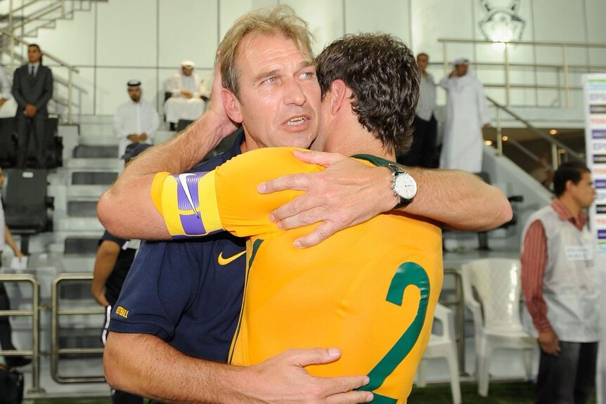 Socceroos coach Pim Verbeek hugs one of the Australian players after a match.
