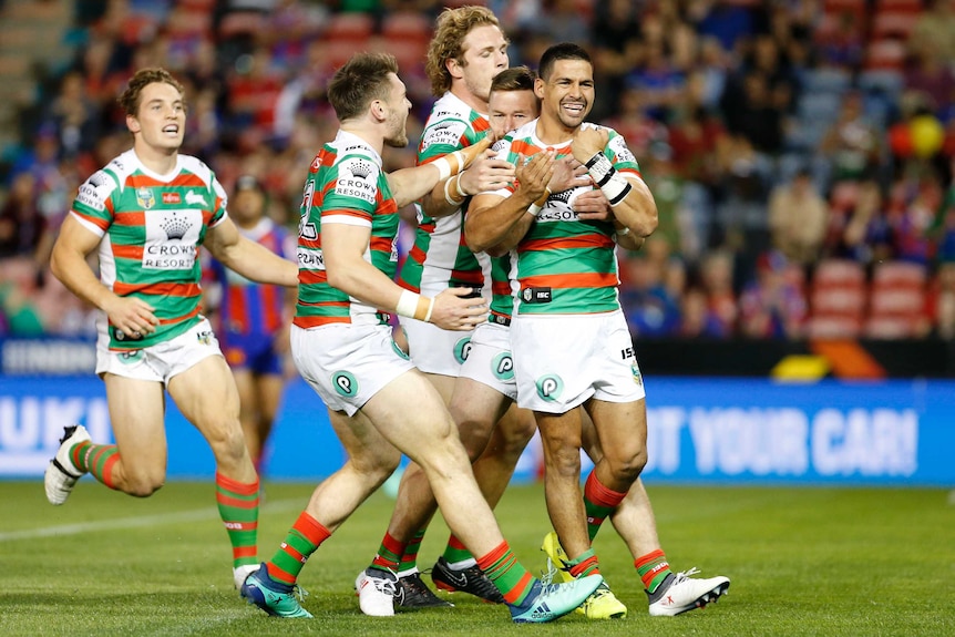 South Sydney crowds around Cody Walker as he celebrates a try against the Knights.