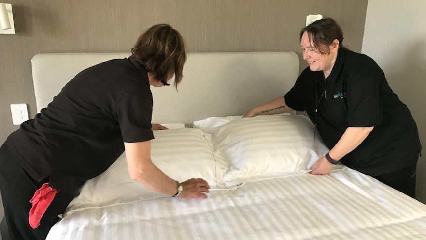 Judy King (left) and Susan Clarke (right) make up a room in preparation for the arrival of Masters Games competitors.