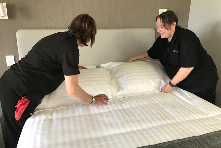 Judy King (left) and Susan Clarke (right) make up a room in preparation for the arrival of Masters Games competitors.