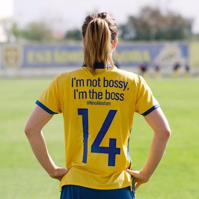 Back of woman's football jersey reads "I'm not bossy, I'm the boss".