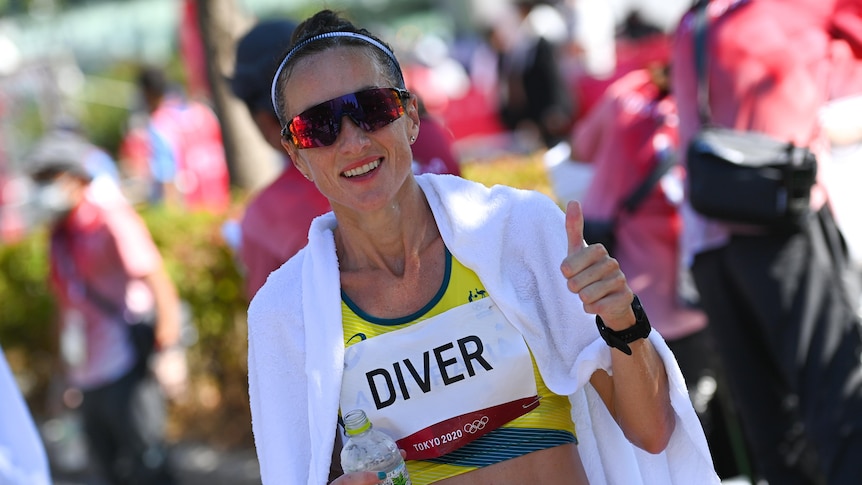 A smiling Australian athlete gives a thumbs up as she is wrapped in an ice towel after the women's marathon.