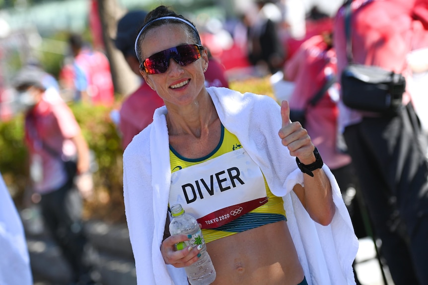 A smiling Australian athlete gives a thumbs up as she is wrapped in an ice towel after the women's marathon.