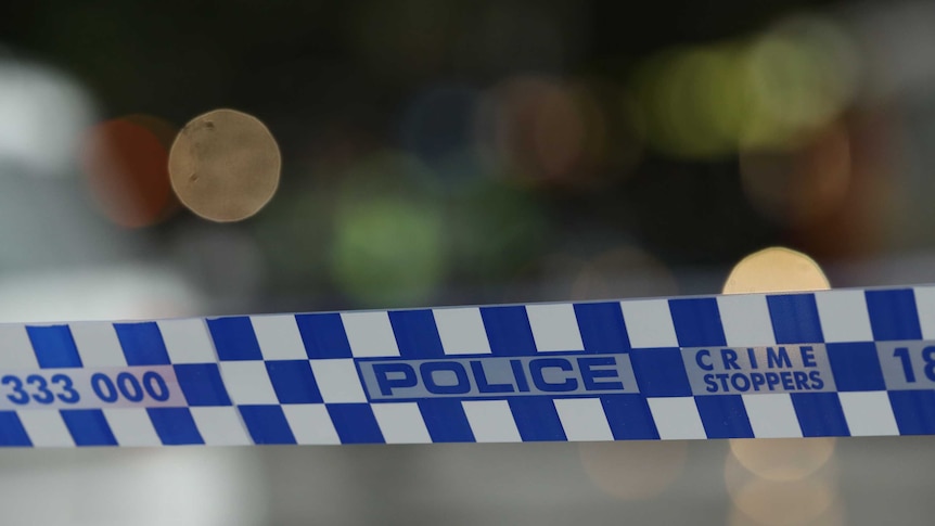 Photograph of blue-and-white Australian police tape, with an out-of-focus background.