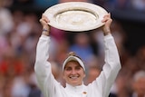 Marketa Vondrousova holds up a plate-shaped golden trophy and smiles