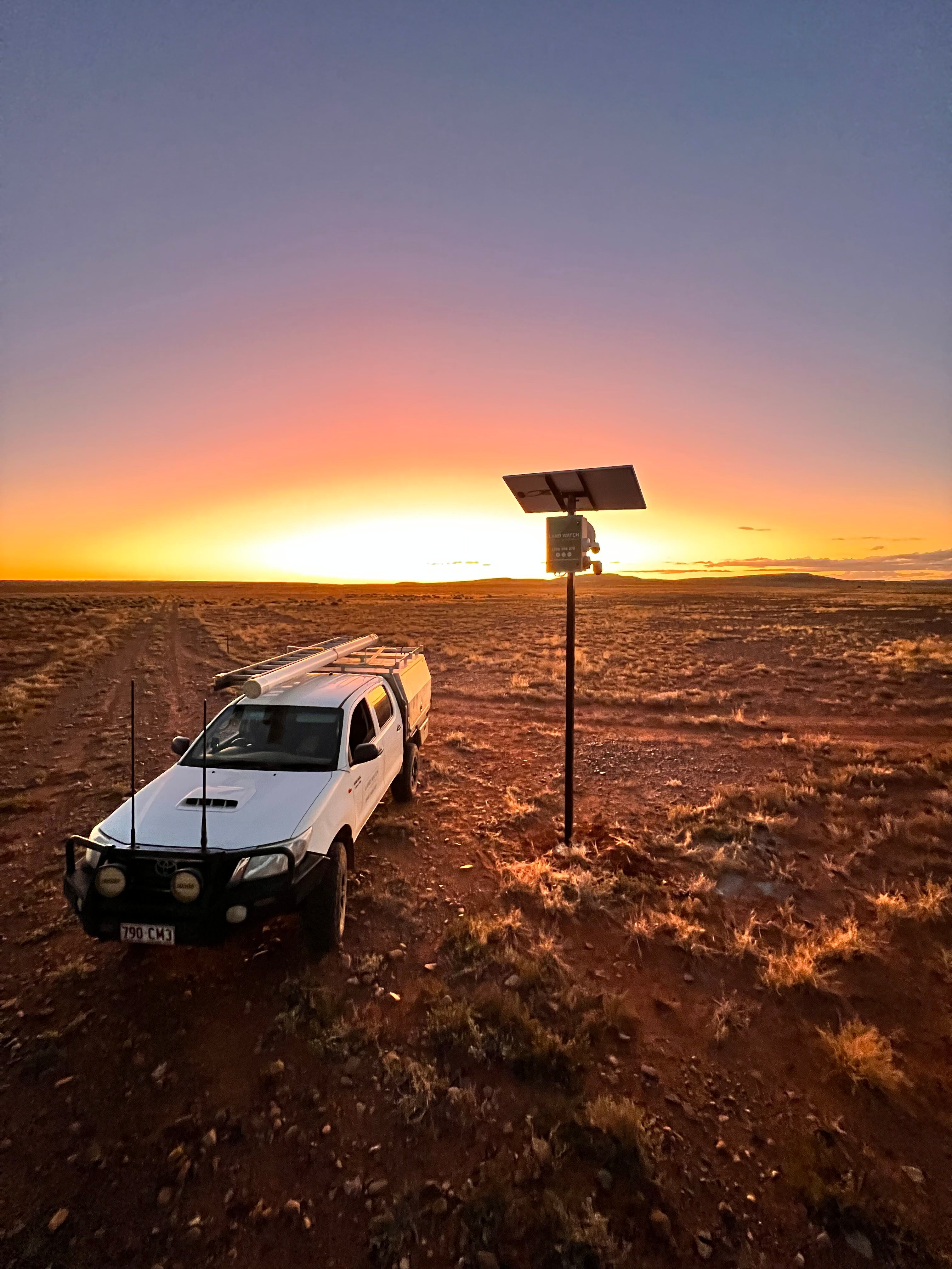 A ute and some farm connectivity equipment at a remote location at sunset.