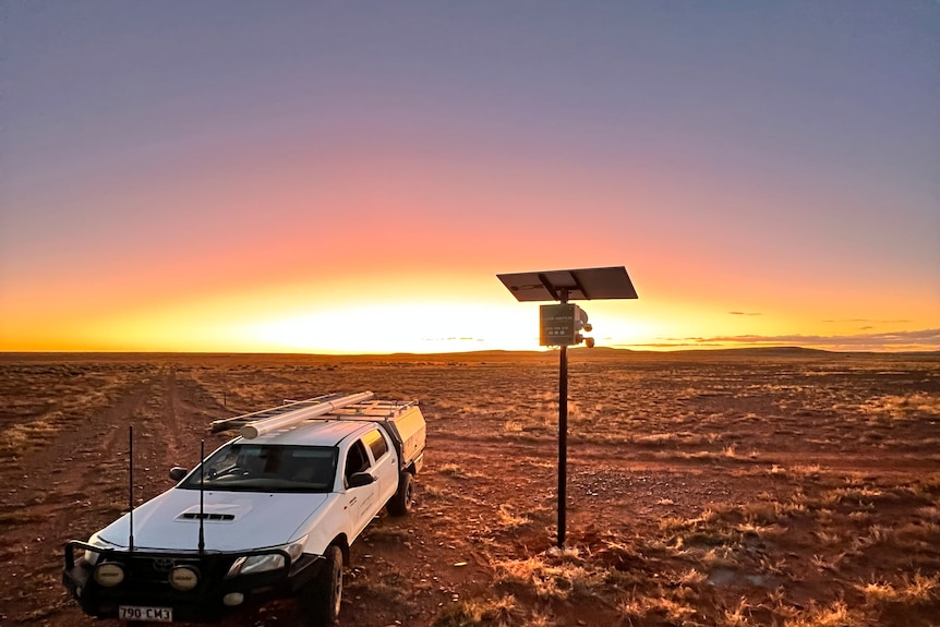 A ute and some farm connectivity equipment at a remote location at sunset.