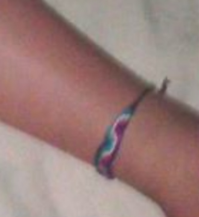 Uma tornozeleira verde roxa e branca. 