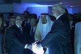 Donald Trump gathers around a glowing sphere with Egypt's President and Saudi Arabia's King.