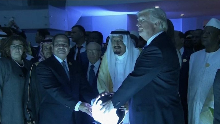 Donald Trump gathers around a glowing sphere with Egypt's President and Saudi Arabia's King.