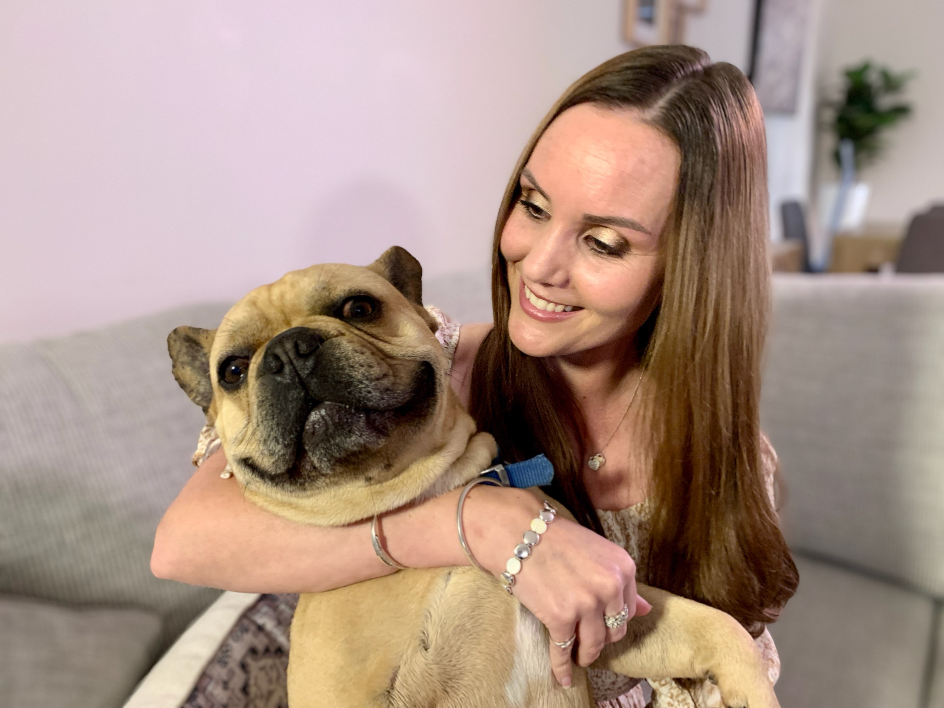 Kristy playing with he dog on the couch