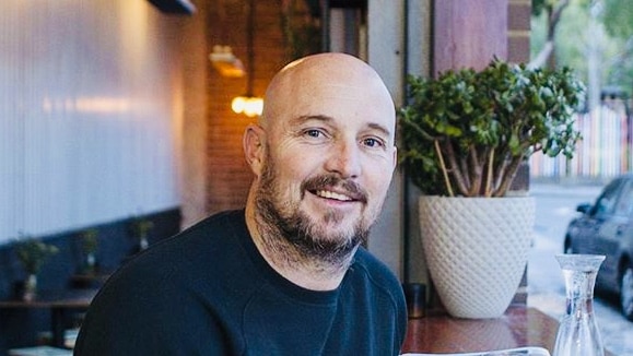 Dean Lloyd sitting in cafe with toast in front of him.