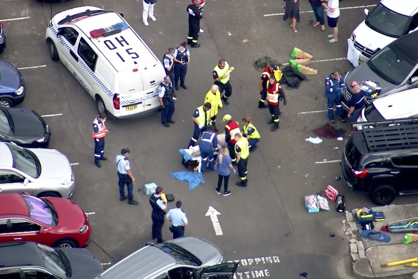 aerial vision of a ambulance workers and police around a person on a stretcher