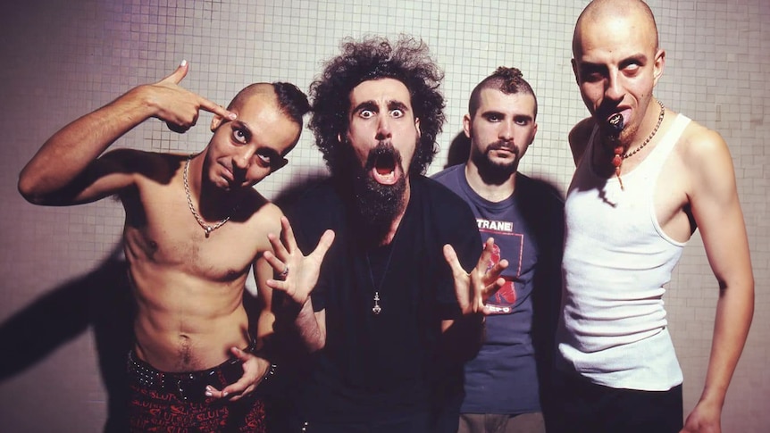 The four members of System Of A Down pose against a tiled wall