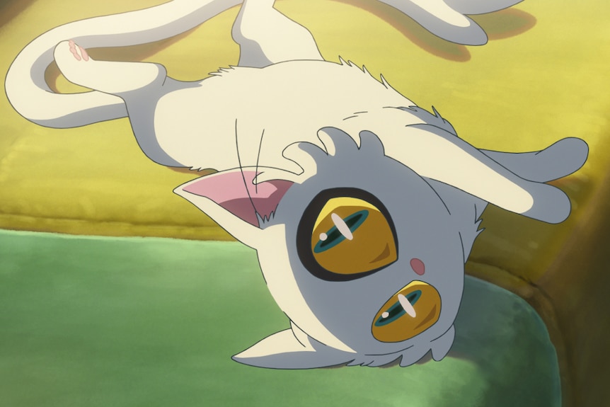 A still from an anime movie, where a white cat with large yellow-green eyes lies on its side on a green lounge, looking up.