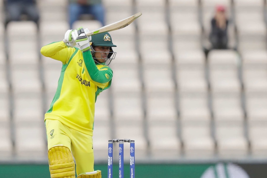 A cricketer's bat points toward the boundary as he hits a four through the offside.