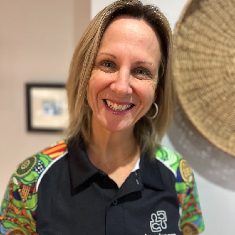 Uma mulher com cabelo de comprimento médio sorri para a câmera 