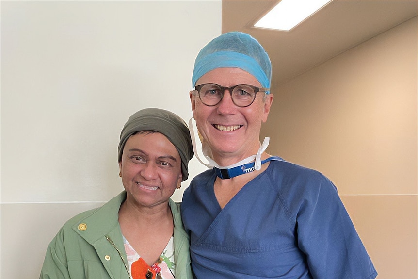 An image of Chamari with Dr Lewis Perrin in surgical scrubs