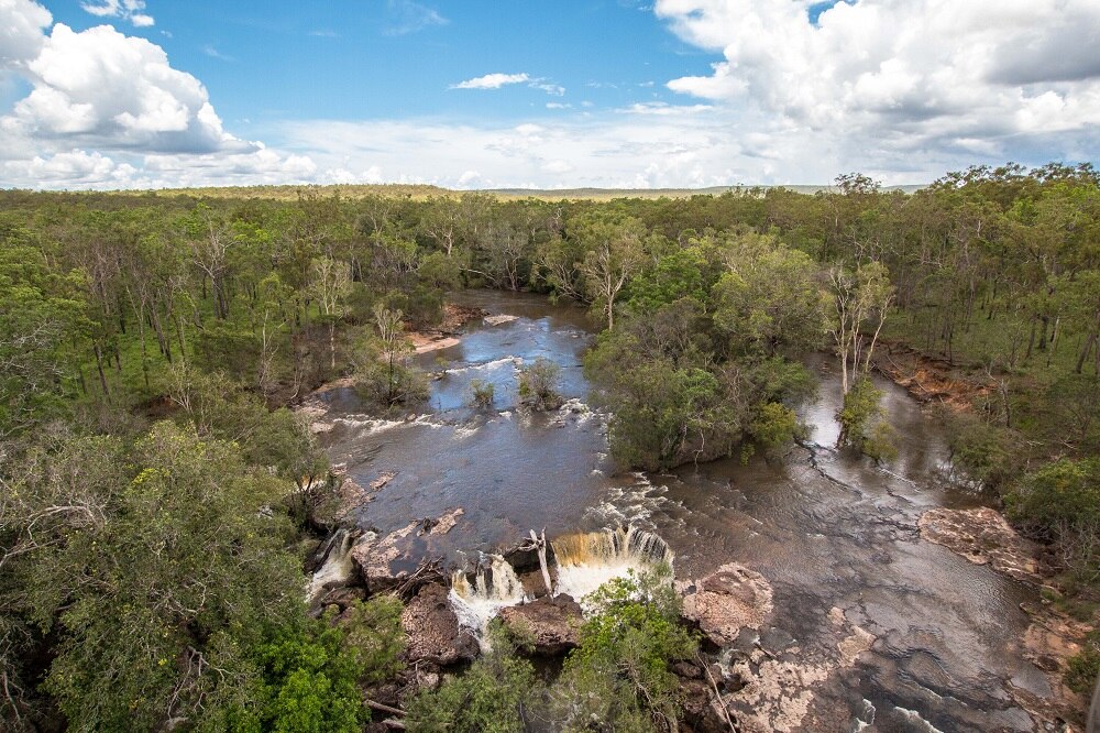 An aerial picture of Wenlock River Falls during wet season, with water running over rocks