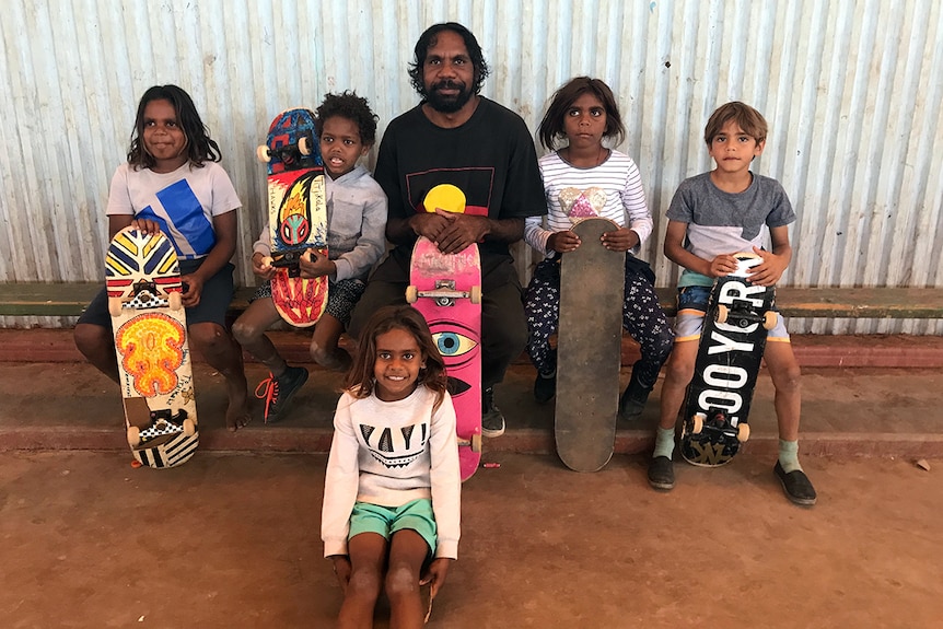 Skateboarder Nicky Hayes sits with children who will enjoy the new skate park.