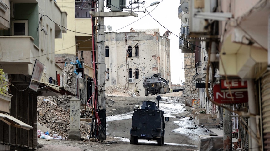 Military vehicles move through the deserted streets of Silvan.