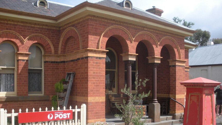 Historic red brick building with Australia Post signage and post box.