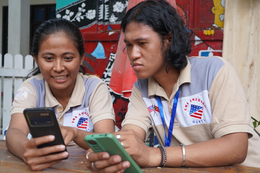 Two young people looking at their phones. 