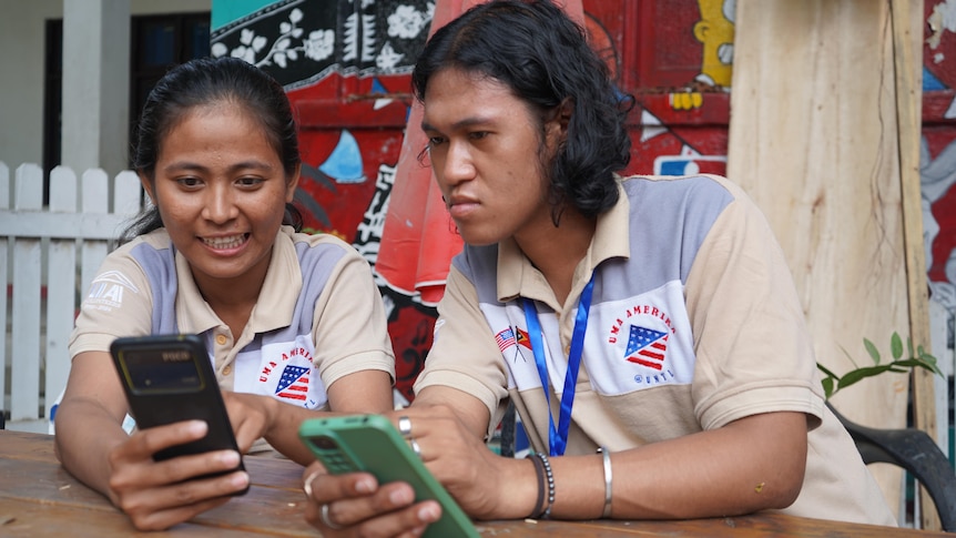 Two young people looking at their phones. 