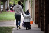 A mother and child go trick or treating in Melbourne for Halloween,