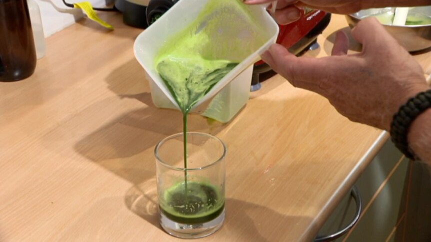 Cannabis juice being poured from a container into a glass