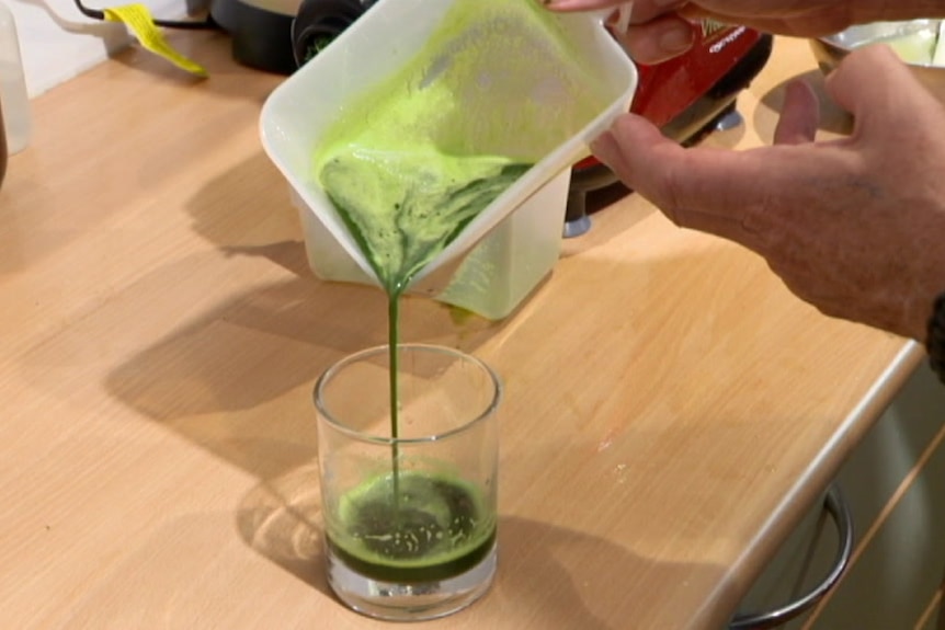 Cannabis juice being poured from a container into a glass