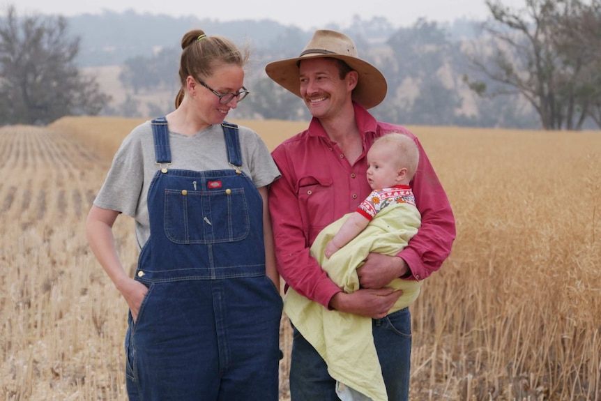 Rohan with wife Laura and baby Morrison outside in a field