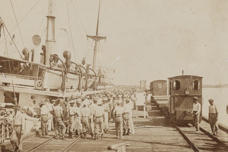 An old photo of pearling crews on a long jetty.
