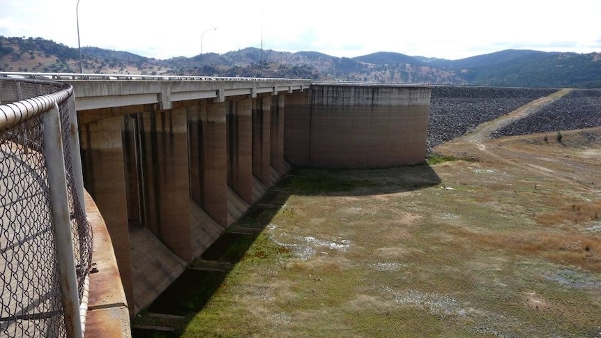 Empty dam with tall cement wall on the left