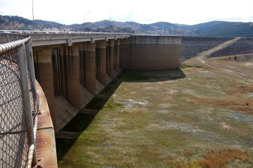 Empty dam with tall cement wall on the left